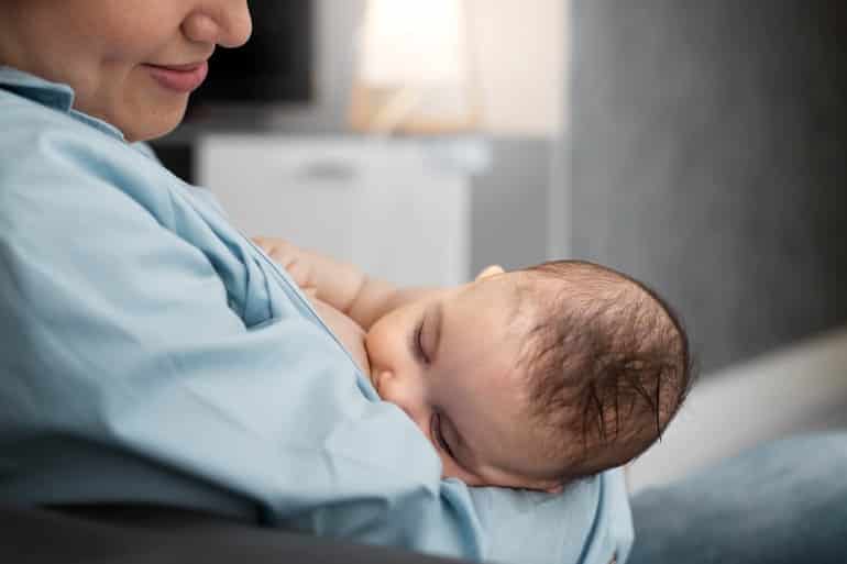 mae com o bebe no colo amamentando