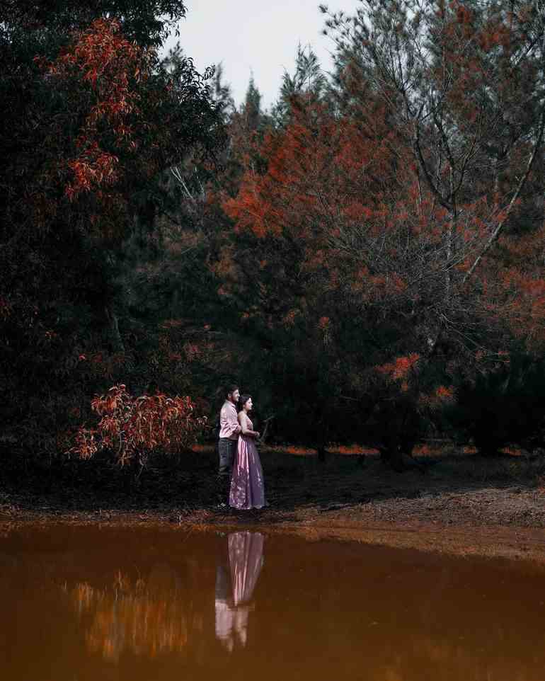 Pré wedding em campo com lago e árvores avermelhadas 